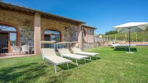 a group of chairs and an umbrella in a yard at Le Masse in Greve in Chianti