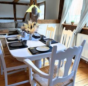 a dining room table with a white table and chairs at Fachwerkwohnung im Weserbergland in Aerzen