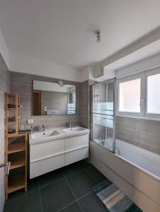 uma casa de banho com 2 lavatórios e um espelho grande em Maison Luxe avec Jardin, 5 Chambres, Home Cinéma - Métro 1 em Vincennes