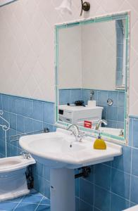 ein Bad mit einem Waschbecken und einem Spiegel in der Unterkunft SUNNY APARTMENT 44 MALTA in Taʼ Xbiex