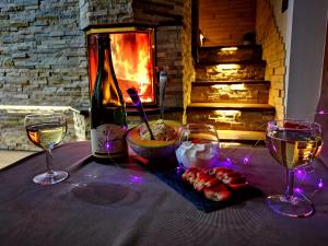 una mesa con dos copas y una botella de vino en Vineyard cottage Matej, en Trebnje