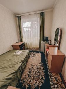 ein Hotelzimmer mit einem Bett und einem Schreibtisch in der Unterkunft Санаторій Червона Калина 