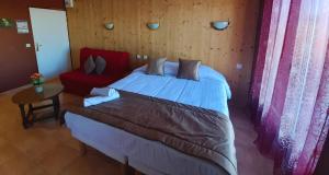 une chambre avec un grand lit et une table dans l'établissement Le Catalan - Hôtel et appartements, à Mont-Louis