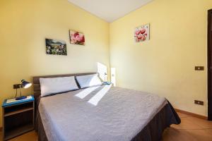 a bedroom with a bed and two pictures on the wall at Appartamento Arlecchino in Gargnano