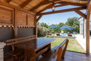 zona de comedor al aire libre con mesa de madera y bancos en Vila Monika, en Nova Vas