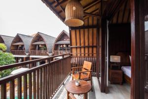 a balcony of a house with a table and a chair at DADEKA Canggu in Canggu