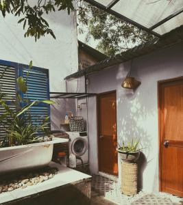 ein Haus mit einer Veranda mit einer Waschmaschine und einer Tür in der Unterkunft Chang's Hideaway homestay ConDao in Con Dao