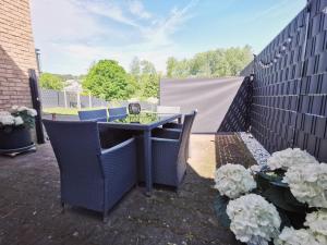 a patio with a table and chairs and a fence at Boxenstopp in der Vulkaneifel in Boos