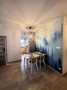 ein Esszimmer mit einem Tisch und einem Gemälde an der Wand in der Unterkunft Apartament Spokojna Wisła in Wisła