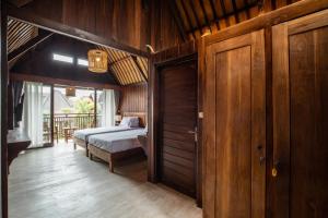 une chambre avec un lit et un mur en bois dans l'établissement Cove Dadeka, à Canggu 17 autres photos