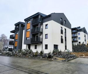 un bâtiment avec une pile de rochers dans un parking dans l'établissement Apartament Spokojna Wisła, à Wisła