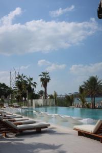 una piscina con tumbonas y palmeras en LUXSeaside/2BD/LaVie/JBR, en Dubái