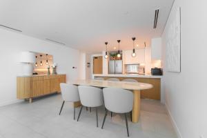 cocina y comedor con mesa de madera y sillas en LUXSeaside/2BD/LaVie/JBR, en Dubái