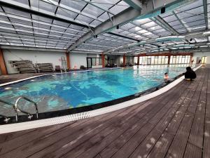 a large swimming pool with a child sitting in front of it at Na Mit HomeStay in Hai Phong
