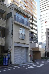 an apartment building with a garage on the side of a street at 駅から徒歩4分/ビル3階全体/広い部屋/広い屋上/和室/レインボーブリッジ/お台場 in Tokyo