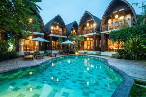a resort with a swimming pool in front of a building at DADEKA Canggu in Canggu