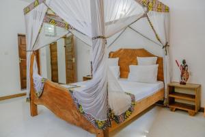 a bedroom with a bed with a mosquito net at Shoki Shoki House Stone Town in Zanzibar City