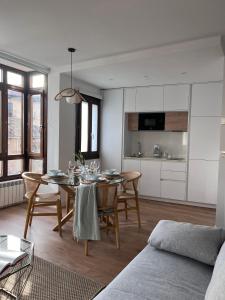 cocina y sala de estar con mesa y sillas en Numancia Suites en Soria