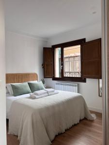 una camera da letto con un grande letto bianco e una finestra di Numancia Suites a Soria