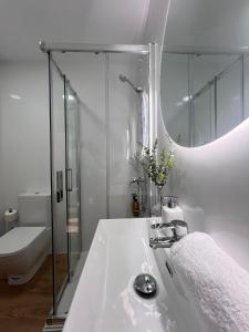 a bathroom with a sink and a toilet and a mirror at Numancia Suites in Soria +60 photos