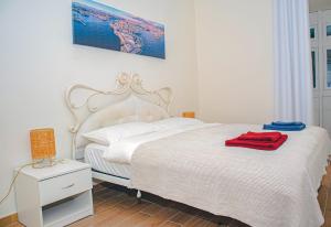 ein Schlafzimmer mit einem weißen Bett und einem roten Handtuch darauf in der Unterkunft SUNNY APARTMENT 44 MALTA in Taʼ Xbiex