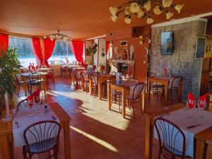 un restaurant avec des tables, des chaises et des rideaux rouges dans l'établissement Le Catalan - Hôtel et appartements, à Mont-Louis