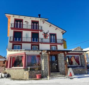 a large white building with a store front at Le Catalan - Hôtel et appartements in Mont-Louis
