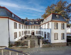 een groot wit gebouw met veel ramen bij Elbershof Monschau in Monschau