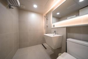 a bathroom with a white toilet and a sink at MONO HOTEL in Suwon