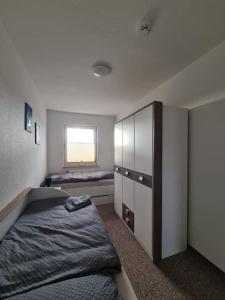 um quarto com uma cama, um armário e uma janela em Gästewohnung KL. WZL 30_5 