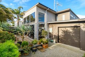 a house with a lot of plants in front of it at Modern Home Central Mount in Mount Maunganui