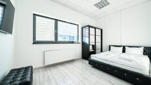 Un dormitorio con una cama y una silla de cuero negro en Apartamenty Sun & Snow Międzyzdrojski Rynek en Międzyzdroje