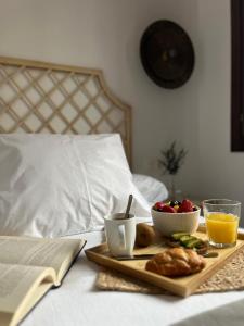 un vassoio con prodotti per la colazione e un libro su un letto di Numancia Suites a Soria