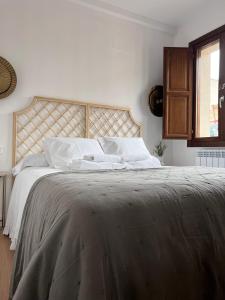 a white bedroom with a large bed with white pillows at Numancia Suites in Soria