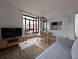 a living room with a couch and a tv and a table at Numancia Suites in Soria