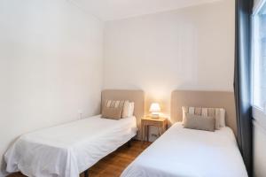 Duas camas num quarto com paredes brancas em Eixample 7 em Barcelona