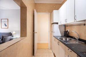uma cozinha com armários brancos e um lavatório em Eixample 7 em Barcelona
