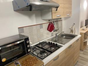 a kitchen with a stove top oven next to a sink at Casuale House in Castel SantʼElia