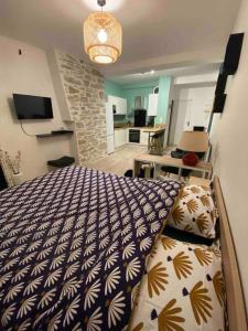 - une chambre dotée d'un lit avec une couverture bleue et blanche dans l'établissement Charmant studio idéalement placé et paisible !, à Oloron-Sainte-Marie