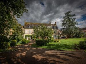 a large house with a grass yard in front of it at Le Prieuré Saint Agnan in Cosne-Cours-sur-Loire