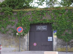 Una gran puerta de garaje negra con un cartel. en Le Prieuré Saint Agnan, en Cosne-Cours-sur-Loire