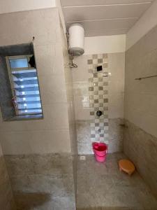 uma casa de banho com um chuveiro com um balde rosa em Hotel kumar em Panchgani