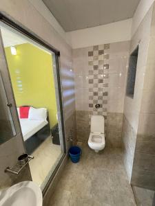 uma casa de banho com um WC, um lavatório e um espelho. em Hotel kumar em Panchgani