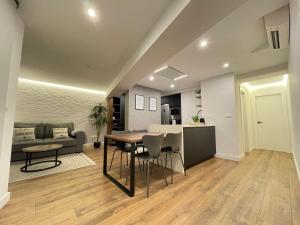 eine Küche und ein Wohnzimmer mit Tisch und Stühlen in der Unterkunft C&G Ático Céntrico con Terraza in Ourense