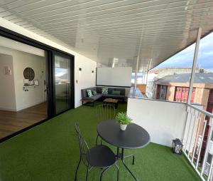 Zimmer mit einem Tisch und Stühlen auf einem Balkon in der Unterkunft C&G Ático Céntrico con Terraza in Ourense