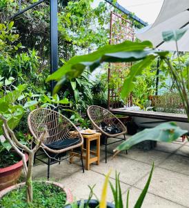 two chairs and a table in a garden at Chang's Hideaway homestay ConDao in Con Dao