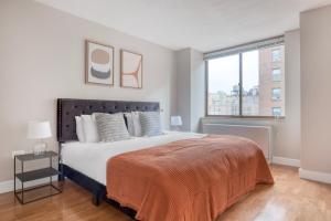 a bedroom with a large bed and a window at UWS 2br w gym doorman elevator nr Central Park NYC-1050 in New York