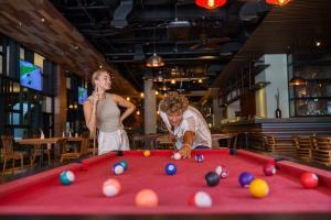 a man and a woman standing next to a pool table at Fairfield by Marriott Bali South Kuta in Kuta