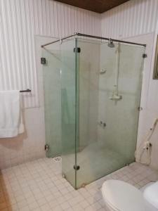 a bathroom with a glass shower with a toilet at silk.hotel in Faisalabad