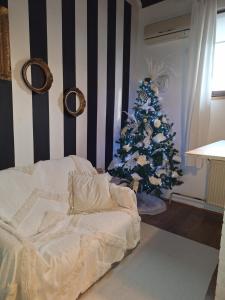 - une chambre avec un arbre de Noël et un lit dans l'établissement Apartman Sissi, à Pančevo